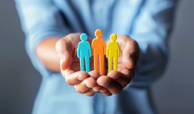 Trois bonhommes bleu, orange et jaune illustrant le partenariat entre une agence de développement et ses clients 