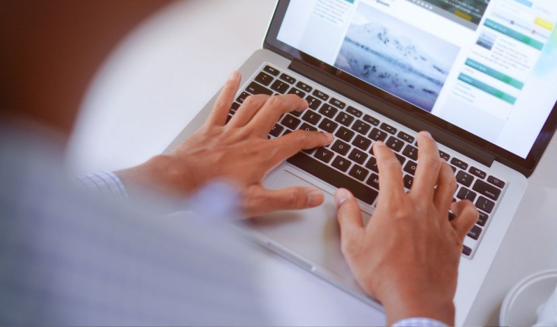 Personne qui rédige du contenu sur le clavier d'un ordinateur portable