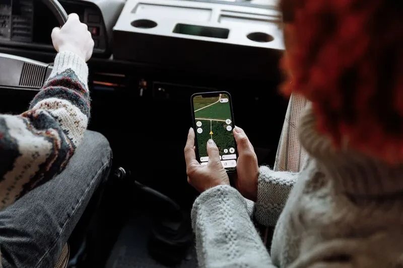 Image d'une femme qui utilise son gps dans un véhicule. La fonctionnalité gps peut être utilisé par Imagine Développement à Vienne (38) pour la création de vos applications mobile sur mesure